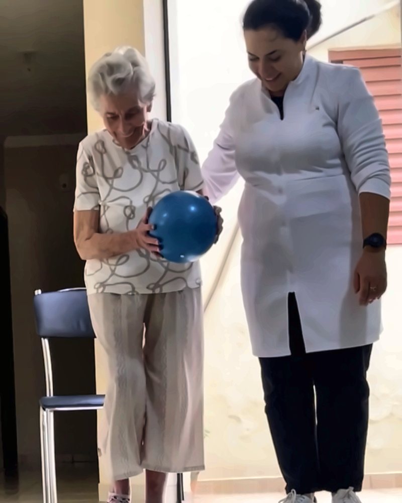 Dra. Talita em treino de equilíbrio com paciente idosa em casa