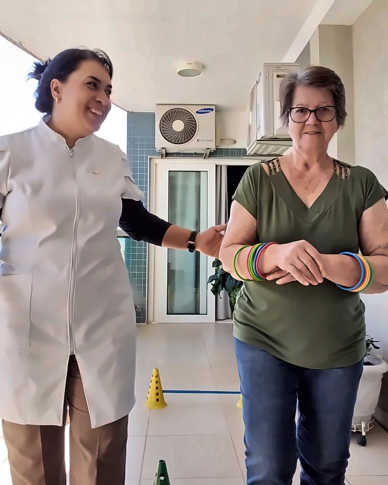 Dra. Talita em treino de marcha com paciente idosa, em casa
